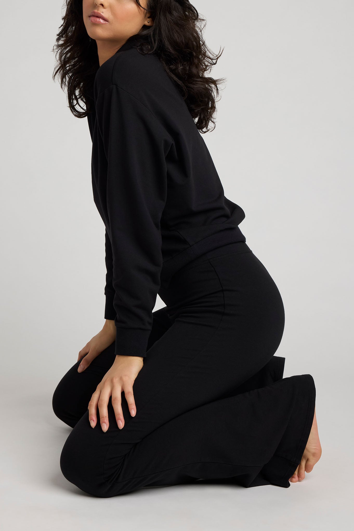 Black club pullover long sleeves and V-neck, side view with draped fit
